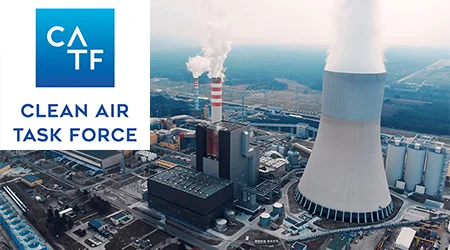 Cheminées industrielles produisant des panaches de fumée. Logo dans le coin supérieur gauche